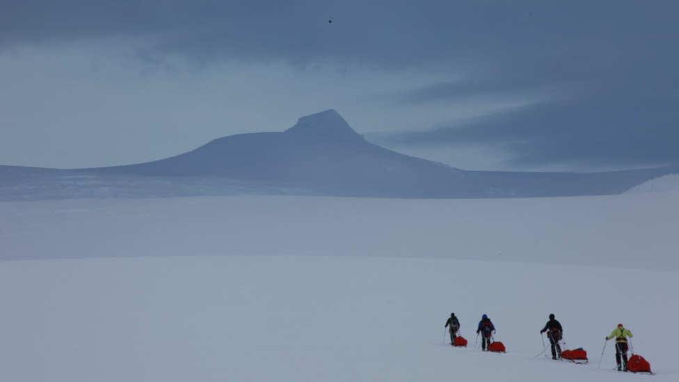 Team make their way across the ice pulling sleds