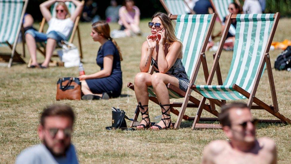 People enjoying the heatwave in Green Park, London