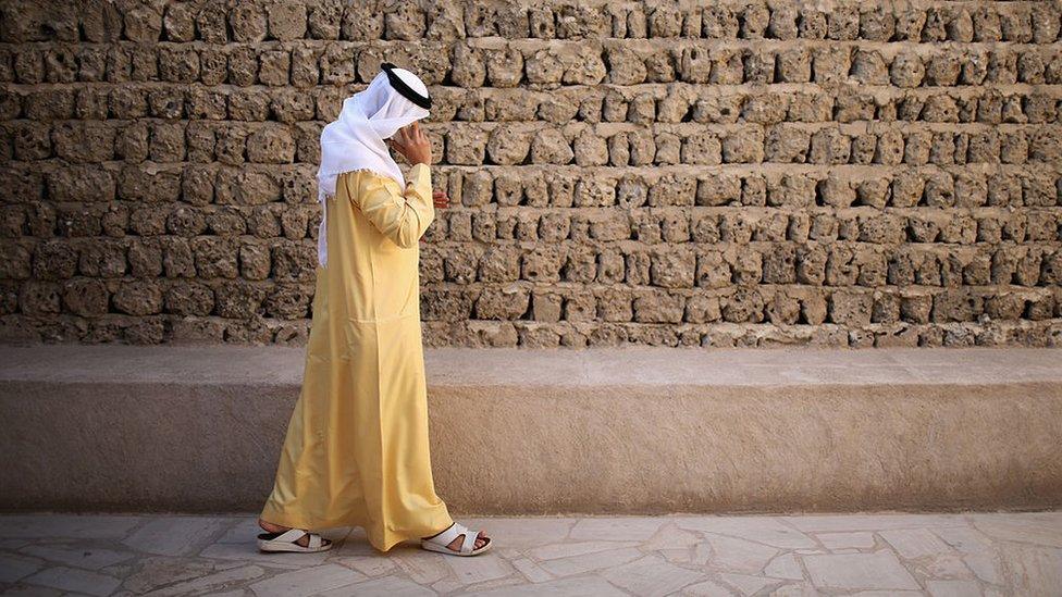 A man talks on his mobile phone as he walks through the Dubai Heritage Village on 13 November 2013 in Dubai, United Arab Emirates