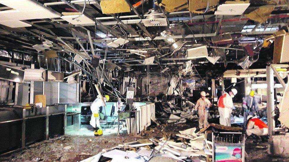 Damage is seen inside the departure terminal at Zaventem airport after the attack on 22 March