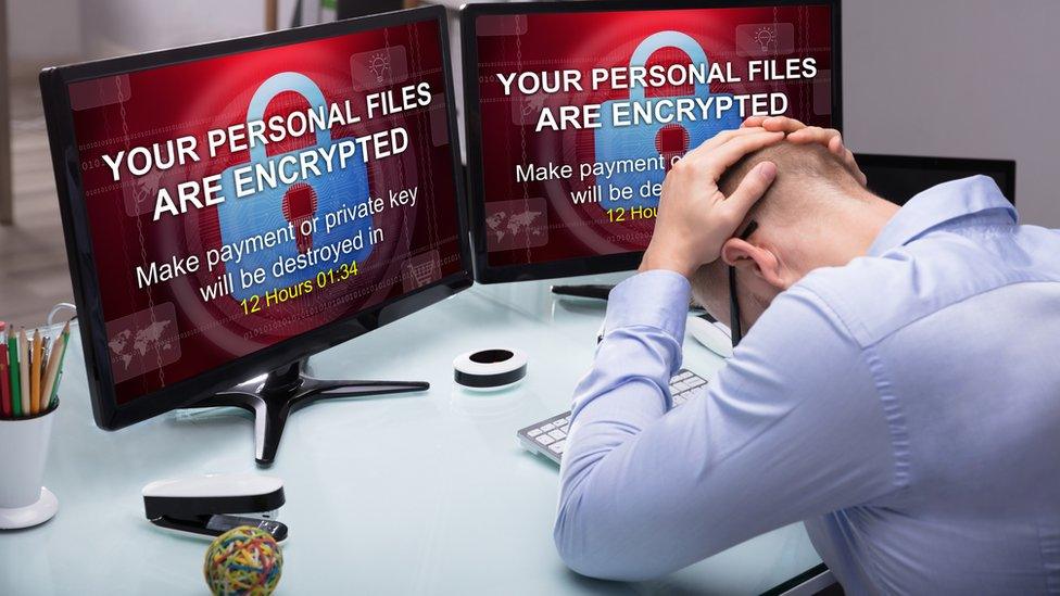 Despairing man in front of hijacked computer screens