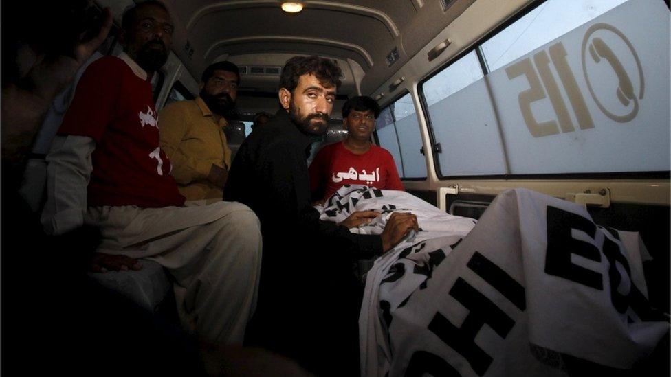 Abdul Majeed, brother of Shafqat Hussain who was convicted of killing a child in 2004, sits in an ambulance beside the body of Safqat after his execution in Karachi, Pakistan, August 4, 2015.