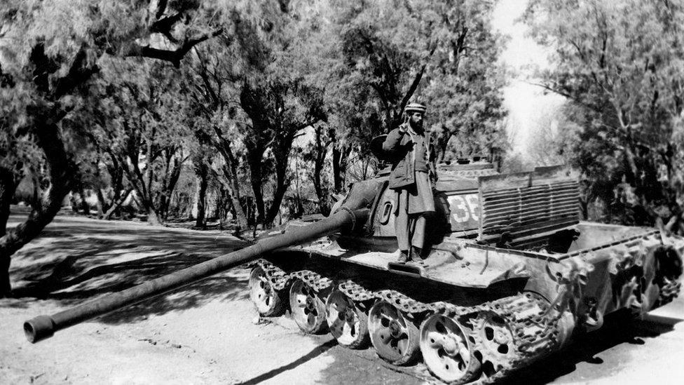 A Mujahideen (mujahidin) stands on a Soviet tank on February 7, 1989 in Torkham, east of Jalalabad, after its capture. (Photo credit should read -/AFP/Getty Images)