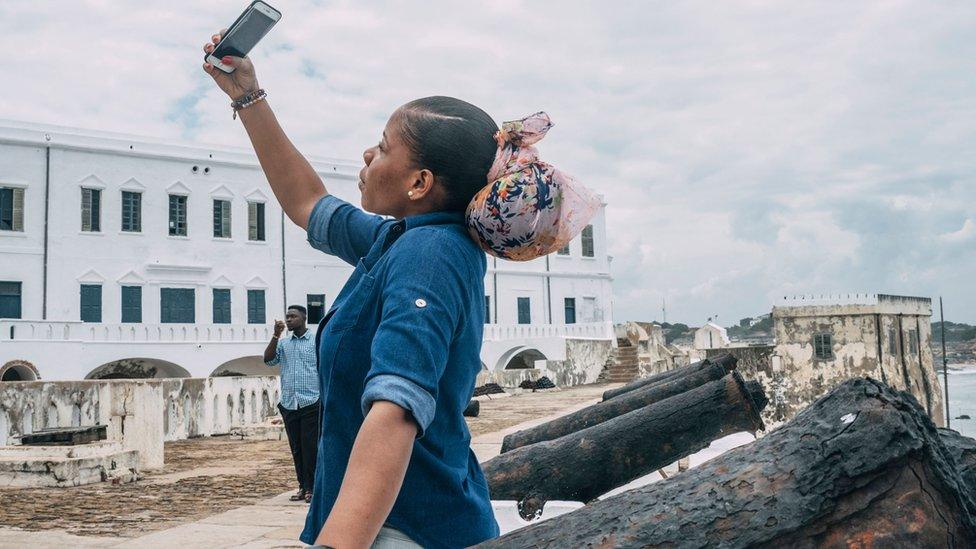 A tourist takes a selfie at the Cape Coast Castle on August 18, 2019