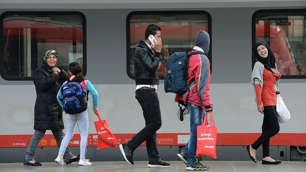 Migrants walk on a platform after their arrival at the main railway station in Munich, southern Germany, on 6 September 2015