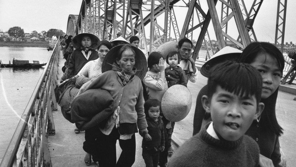 9th February 1968: A group of Vietnamese refugees crossing a bridge over the Perfume River