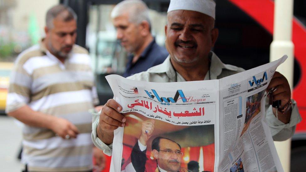 Man reading a newspaper in Iraq