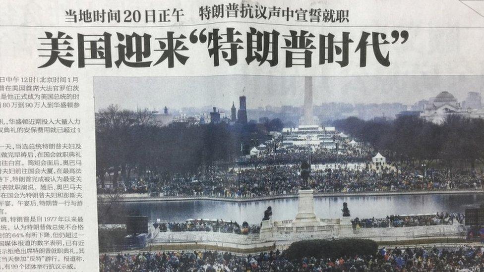 A photograph of a Chinese newspaper front page, showing a picture from Donald Trump's inauguration.