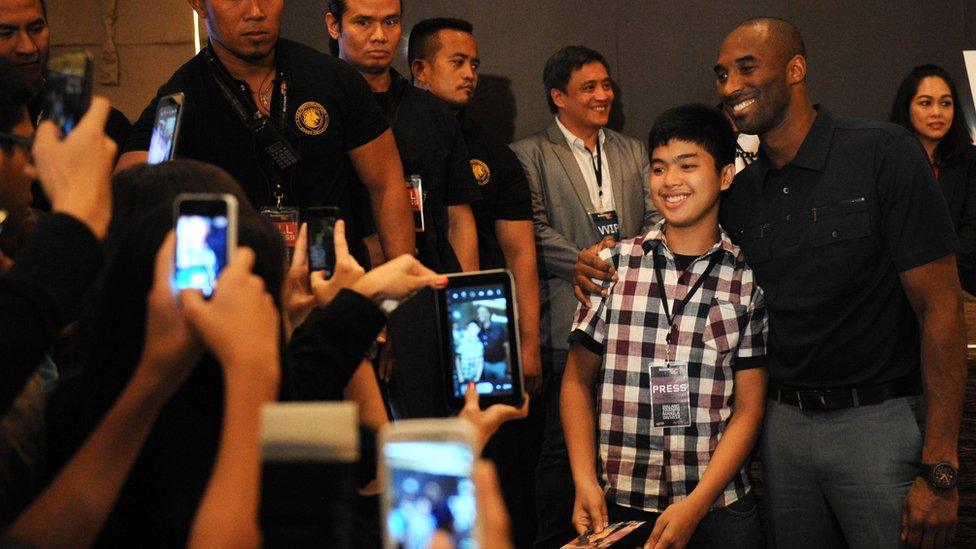 Kobe Bryant poses with a fan in Manila, Philippines in 2013