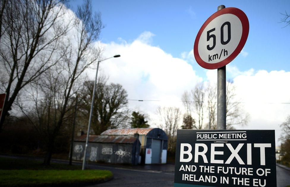 A former customs hut is seen behind a Brexit sign between Donegal in the Republic of Ireland and Londonderry in Northern Ireland at the border village of Muff, in February 2018