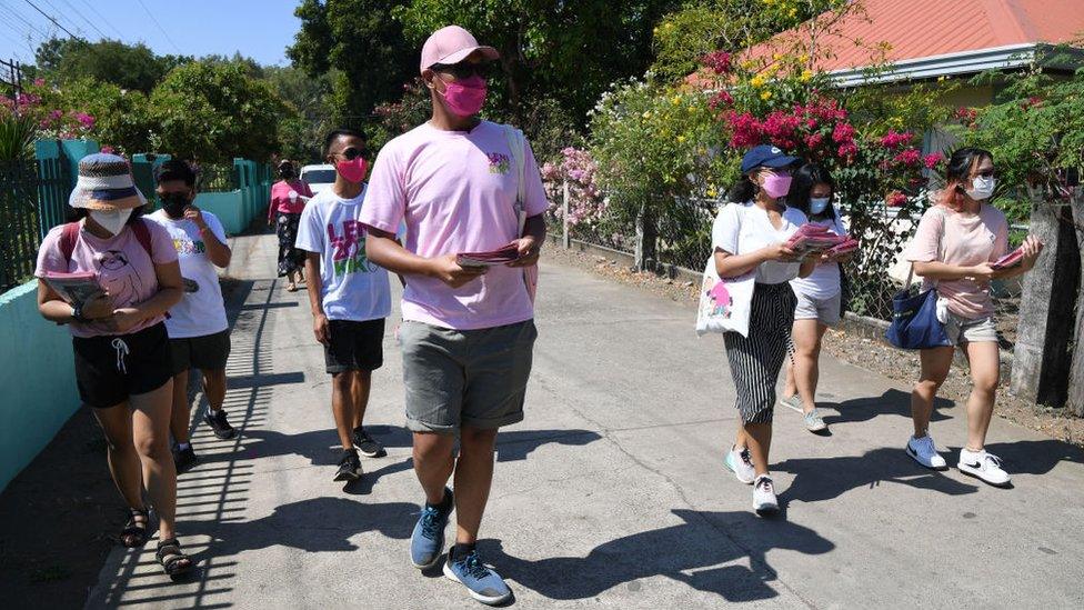 Volunteers for opposition presidential candidate and current vice president, Leni Robredo, distributing fliers to residents during a house-to-house campaign in the town of Pasuquin, Ilocos Norte province.