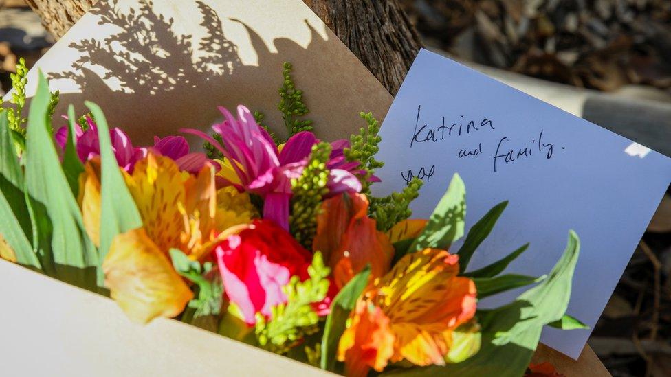 Flowers and a note are left next to a police roadblock where police are investigating the death of seven people in a suspected murder-suicide in Osmington, Western Australia