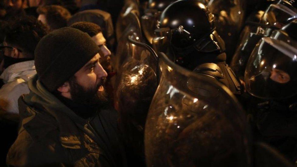 Protesters face off against riot police