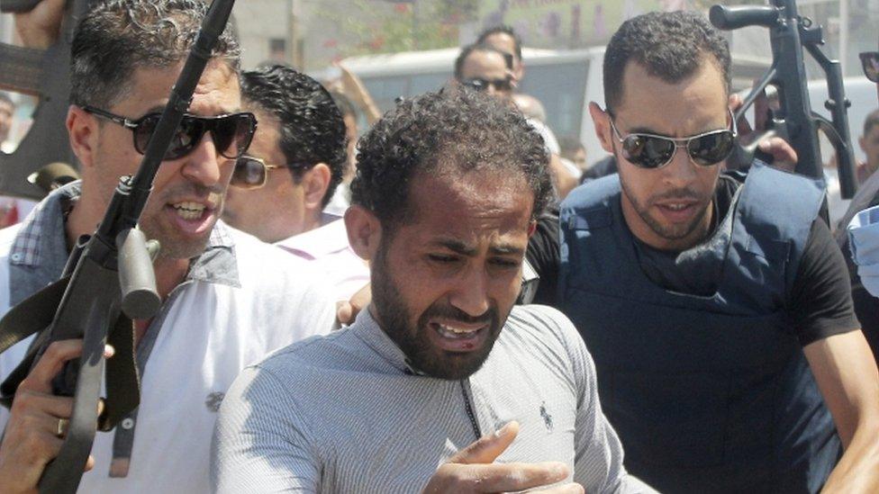 Police officers surround a man (C) suspected to be involved in an attack on a beachside hotel in Sousse, Tunisia June 26, 2015.