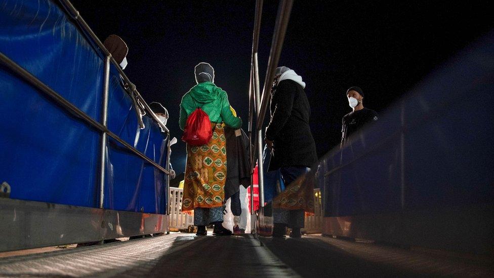 Two refugees disembark in Italian safe harbour after being rescued attempting to cross from Tunisia