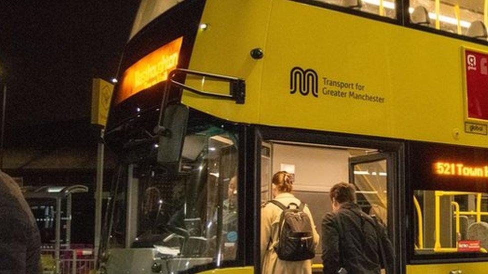 Andy Burnham by a Bee Network buses during the night