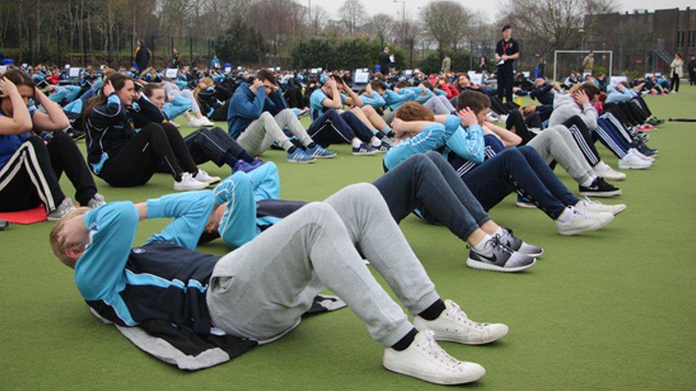 Staff and pupils doing sit-up exercises during the world record attempt