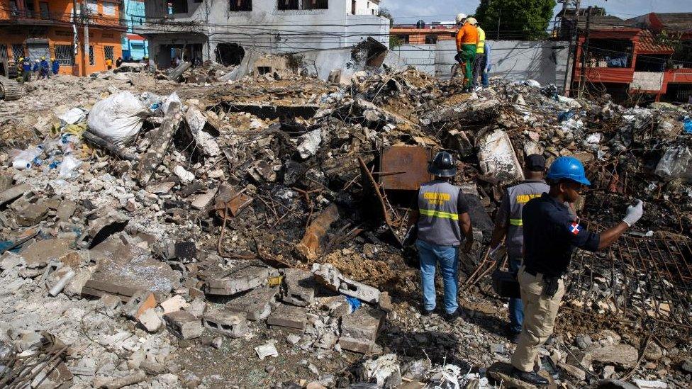 Rescue workers search for missing persons among the rubble the day after an explosion occurred in San Cristobal, Dominican Republic, 15 August 2023.