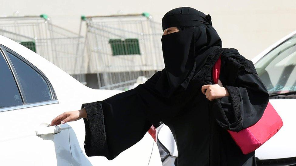 Woman in Saudi Arabia opening a car door