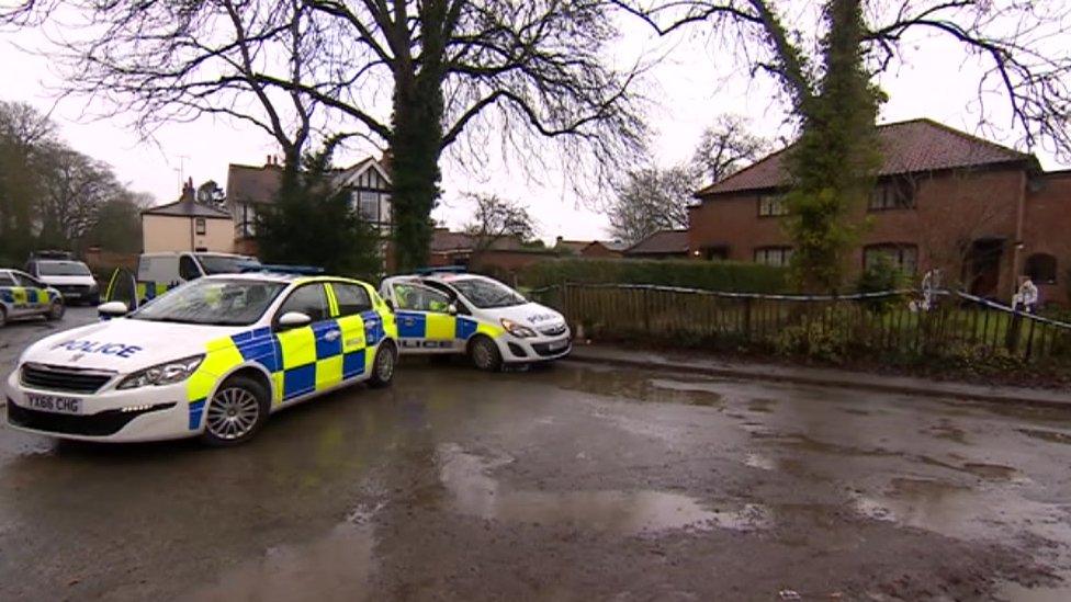 Police cars parked in front of a house