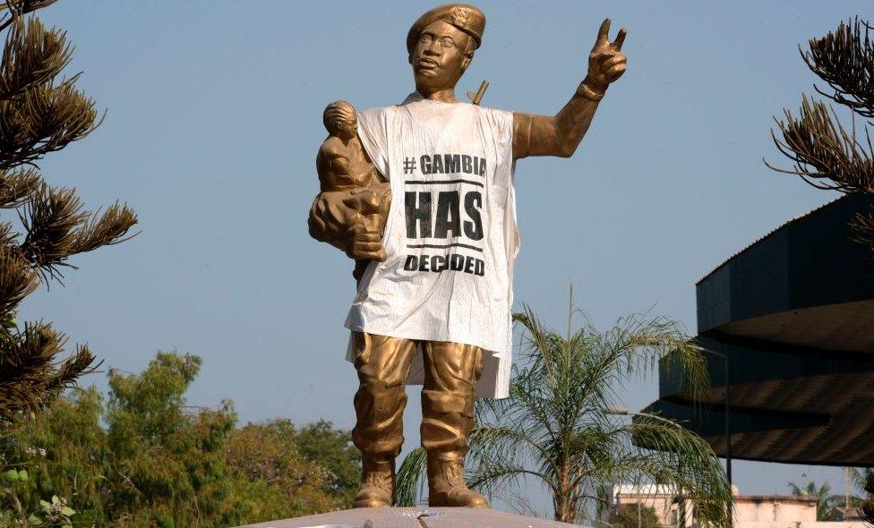 A figure of the Arch 22 monument to mark the July 22, 1994 bloodless coup led by former President Yahya Jammeh is draped with a shirt-shaped banner reading 'Gambia has decided', in Banjul on April 3, 2017