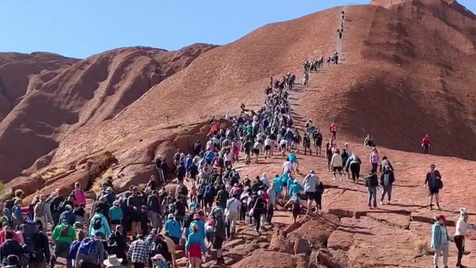 A crowd of climbers scaling Uluru on 2 October 2019