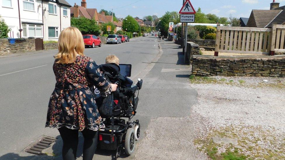 Sharon Davis takes Josh Higginbottom down the road in his wheelchair