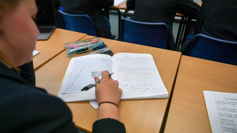 A student in class with a notebook