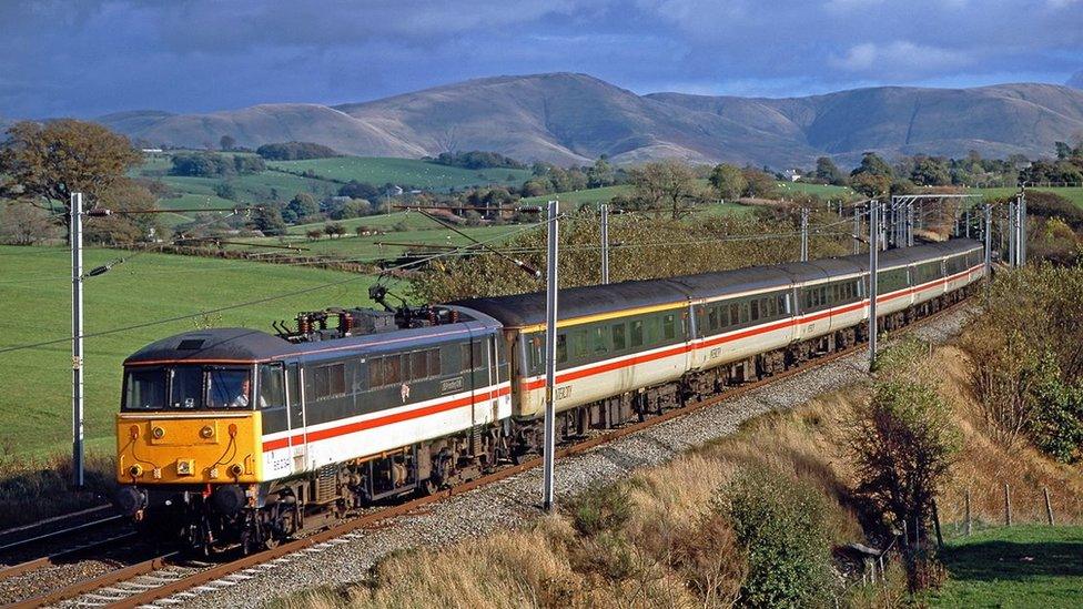 A train on track with hills behind