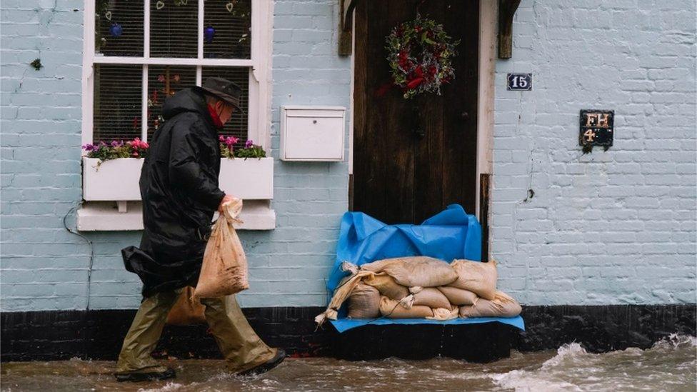 A man places sand bags outside a property in Langstone, Hampshire