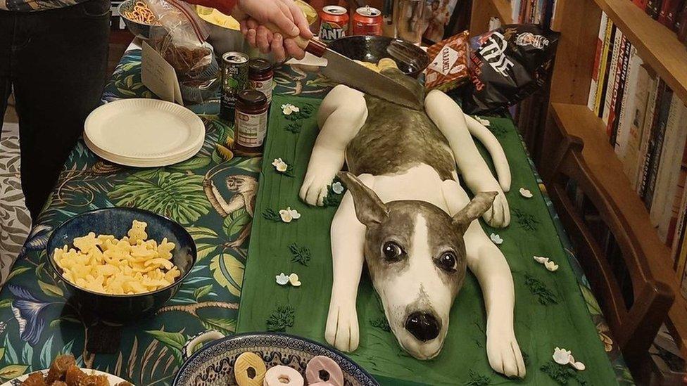 dog cake on table with party rings and crisps