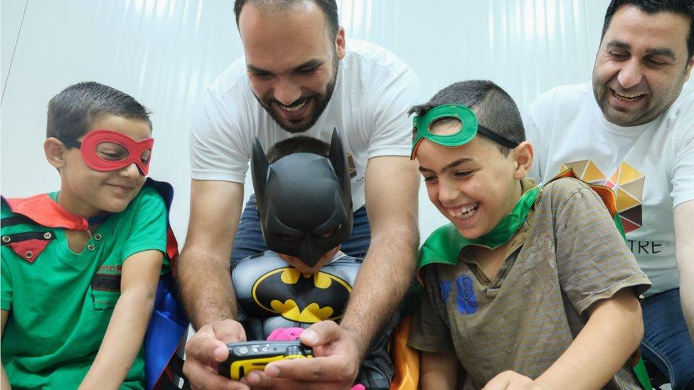 Charity workers with boys dressed as superheroes