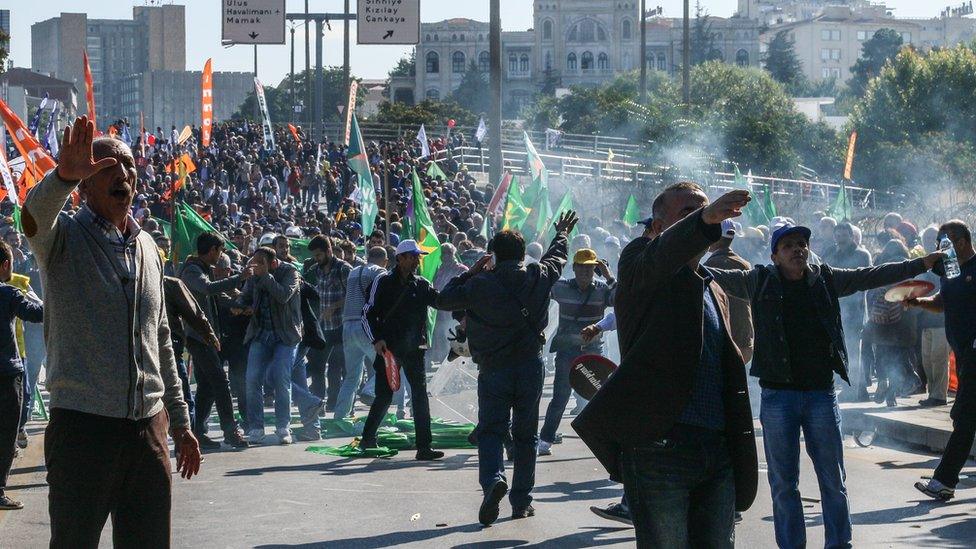 A crowd reacting after tear gas was thrown by police in Ankara, Turkey, Saturday 10 October 2015