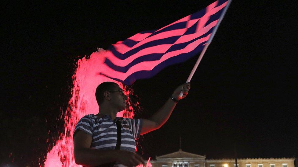 A "No" supporter waves a Greek flag by the parliament in Athens, Greece 5 July 2015.