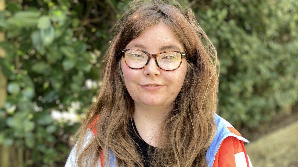 Young woman sitting on a park bench in Norwich