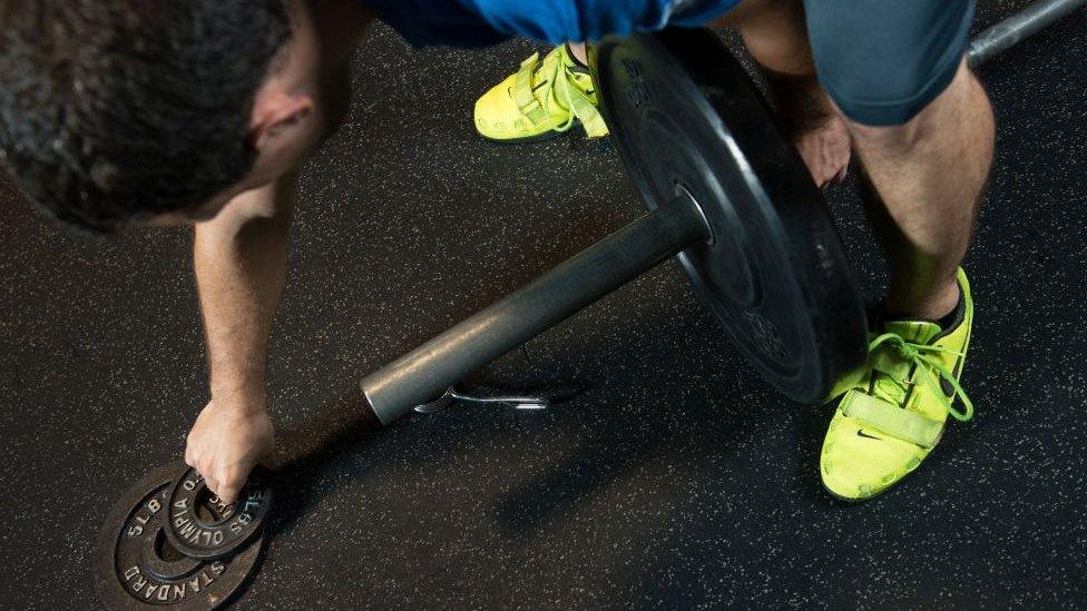 An unidentifiable man working out at a CrossFit gym