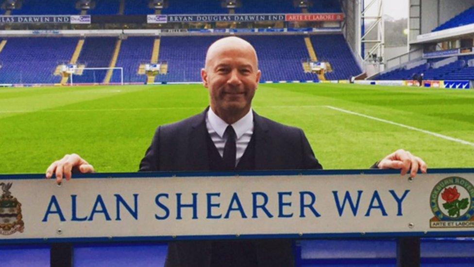 Alan-Shearer-holding-street-sign-for-Alan-Shearer-way.