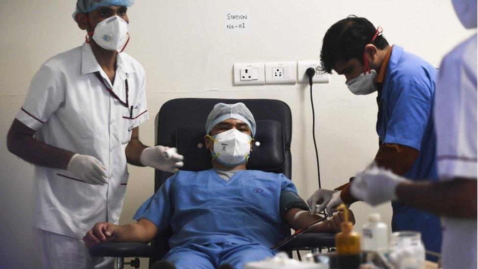 A plasma donor (C) is seen at the newly inaugurated plasma bank of the Institute of Liver and Biliary Sciences (ILBS) donating plasma for the treatment of patients suffering from the COVID-19 coronavirus, in New Delhi on July 2, 2020.