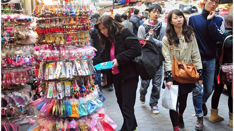 People walk through a shopping district in Seoul