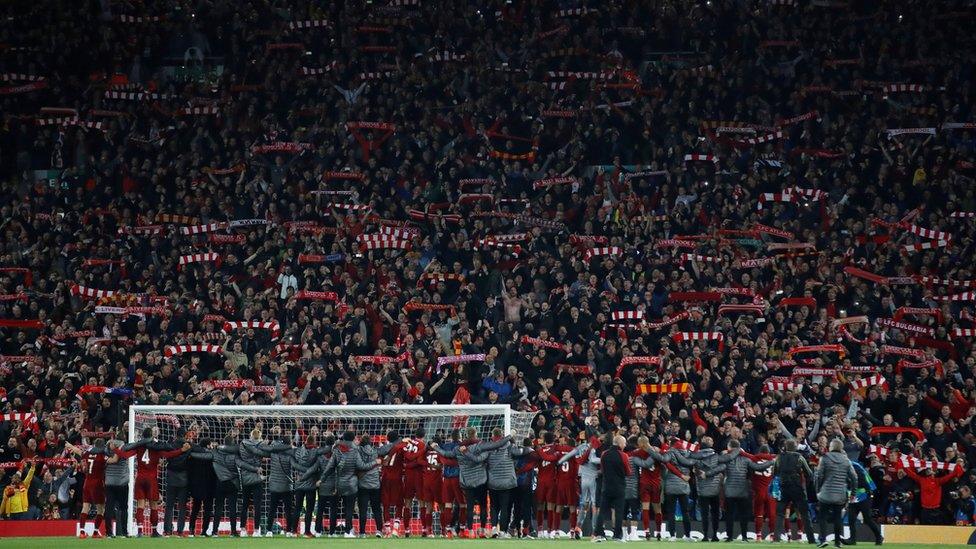 Liverpool players and staff celebrating the Champions League semi-final win against Barcelona with fans in the Kop