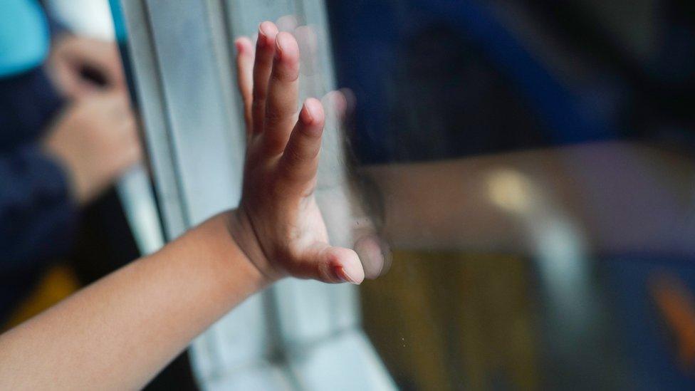 Child hand on window