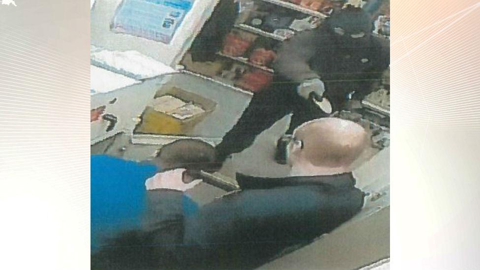 Balaclava-clad robber holding knife