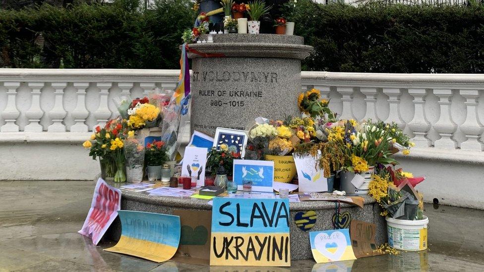 Flowers at the base of a statue to Ukraine's St Volodymyr in London