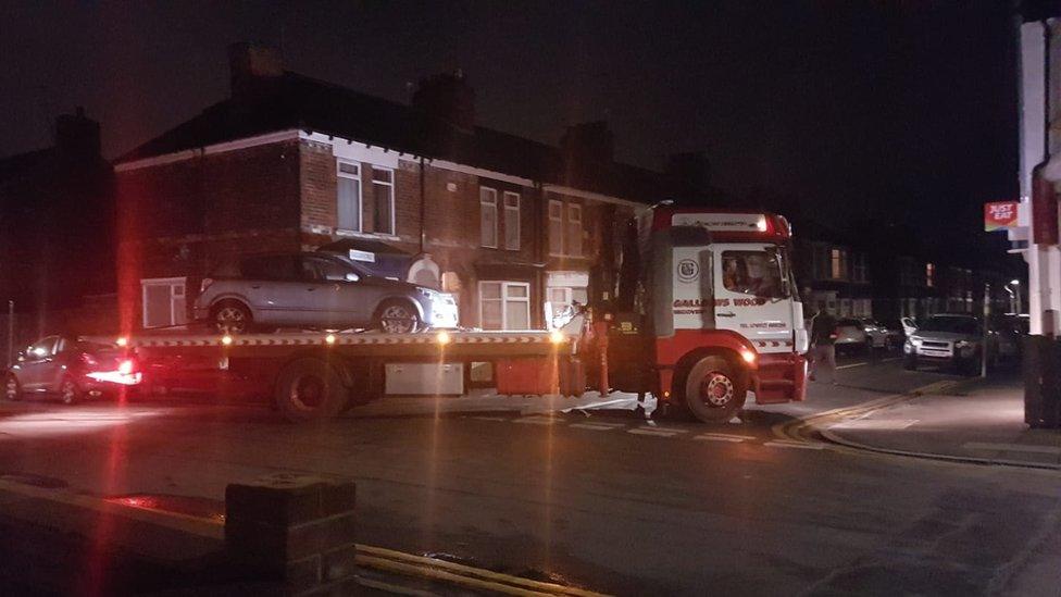 Silver car being towed