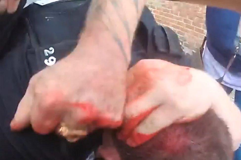 Body cam still of fist punching towards PC's head