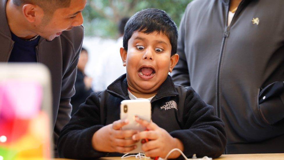 A boy looks shocked looking at his phone