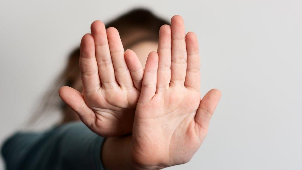 Girl holding hands out in a stop gesture