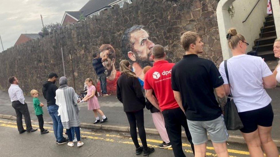 Crowds watch the mural being created