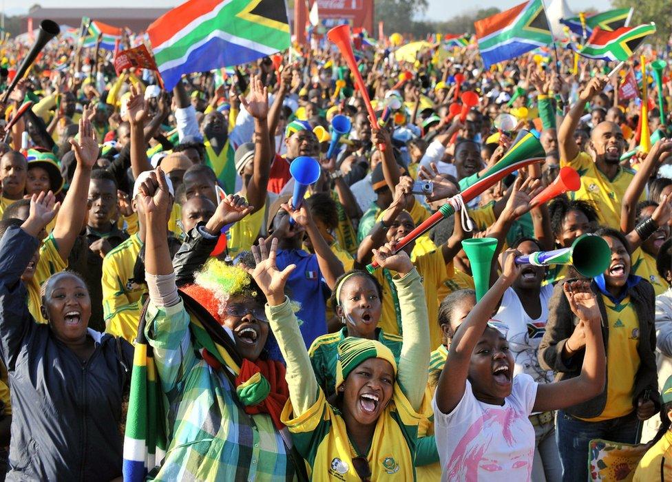 Football fans cheer as they watch a live broadcast at Fields College in Rustenburg of the 2010 World Cup opening match between South Africa and Mexico