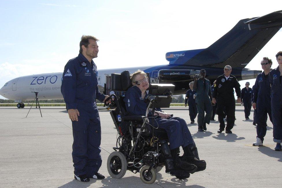 Stephen Hawking waits next to a plane